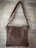 Back view of the Azure Aesthetic Leather & Hairon Bag hanging on a brick wall.