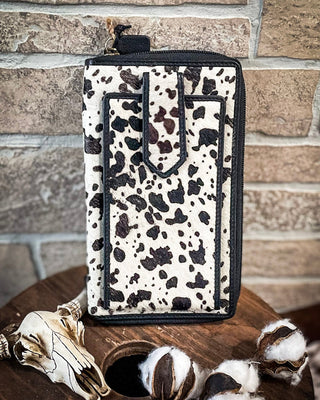 Spotted pouch on a wooden surface with a stone wall background